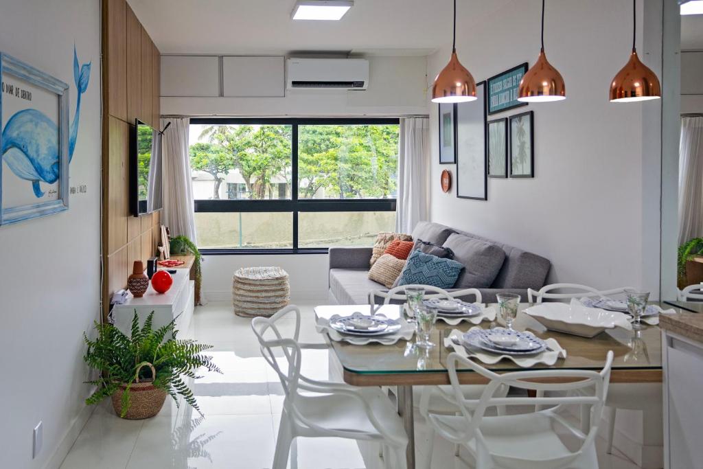 萨尔瓦多Apartamento Aconchegante Beira-Mar Ondina的厨房以及带桌椅的起居室。