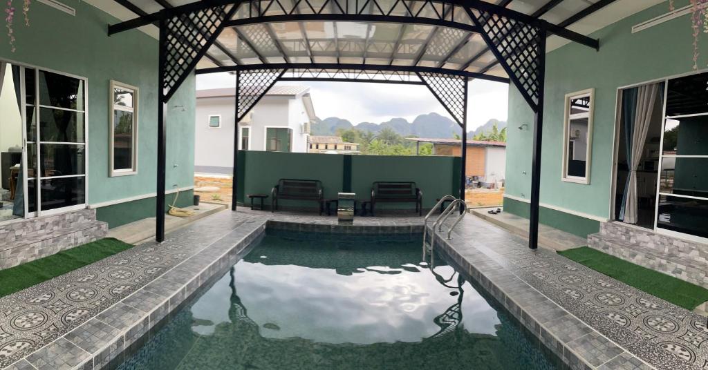 淡文Teratak Sakinah Guest House的庭院中带游泳池的房子