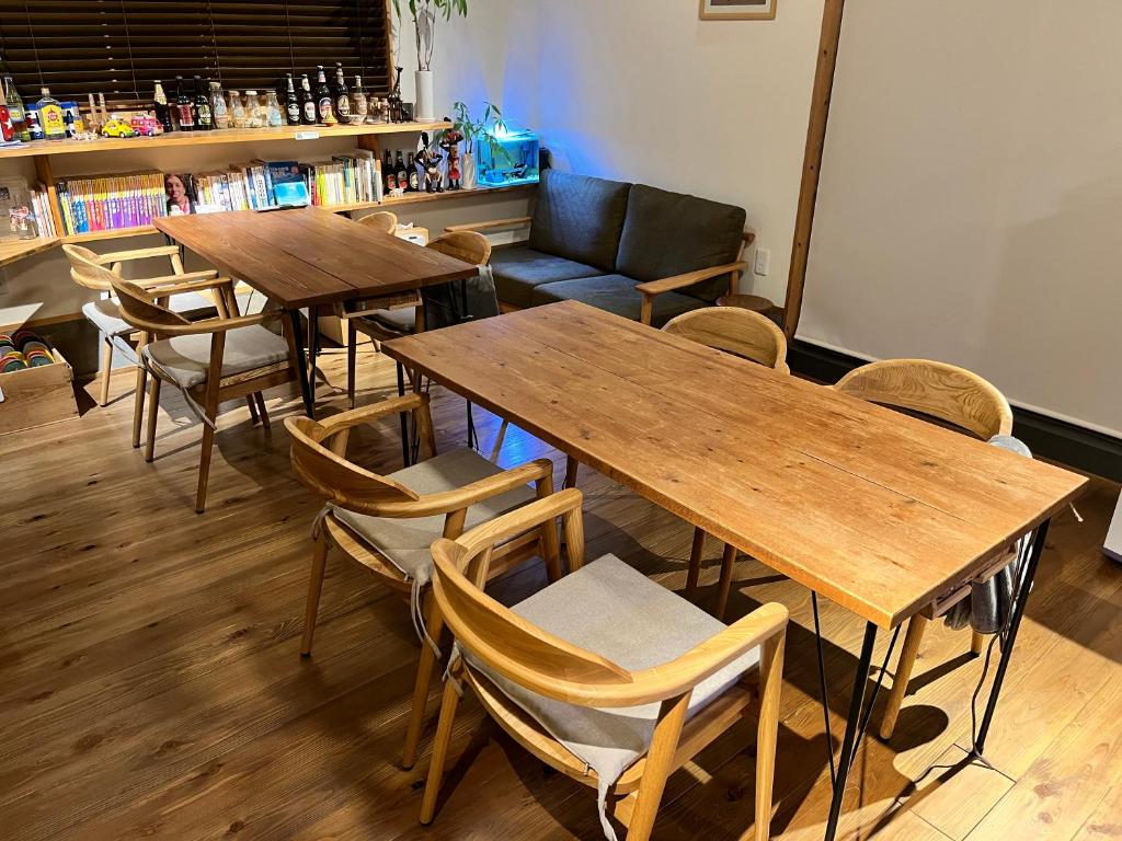 Shinkamigoto五岛背包客标杆旅舍的餐厅设有木桌、椅子和沙发。