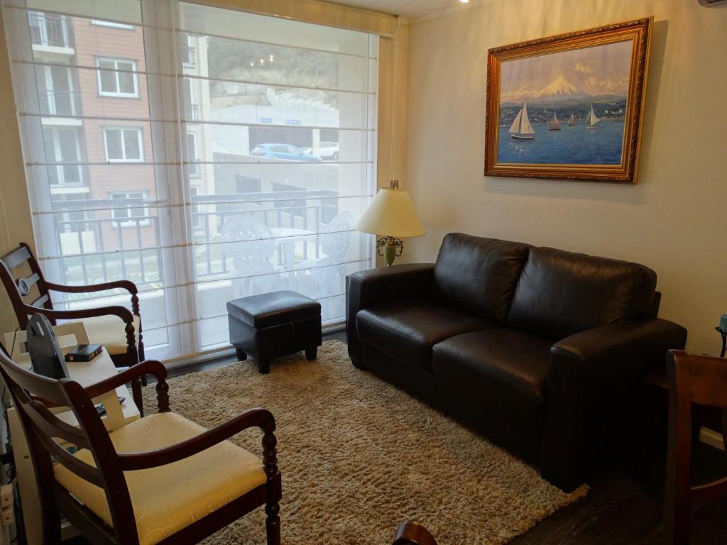 巴拉斯港Apart & Tour的客厅配有真皮沙发和窗户