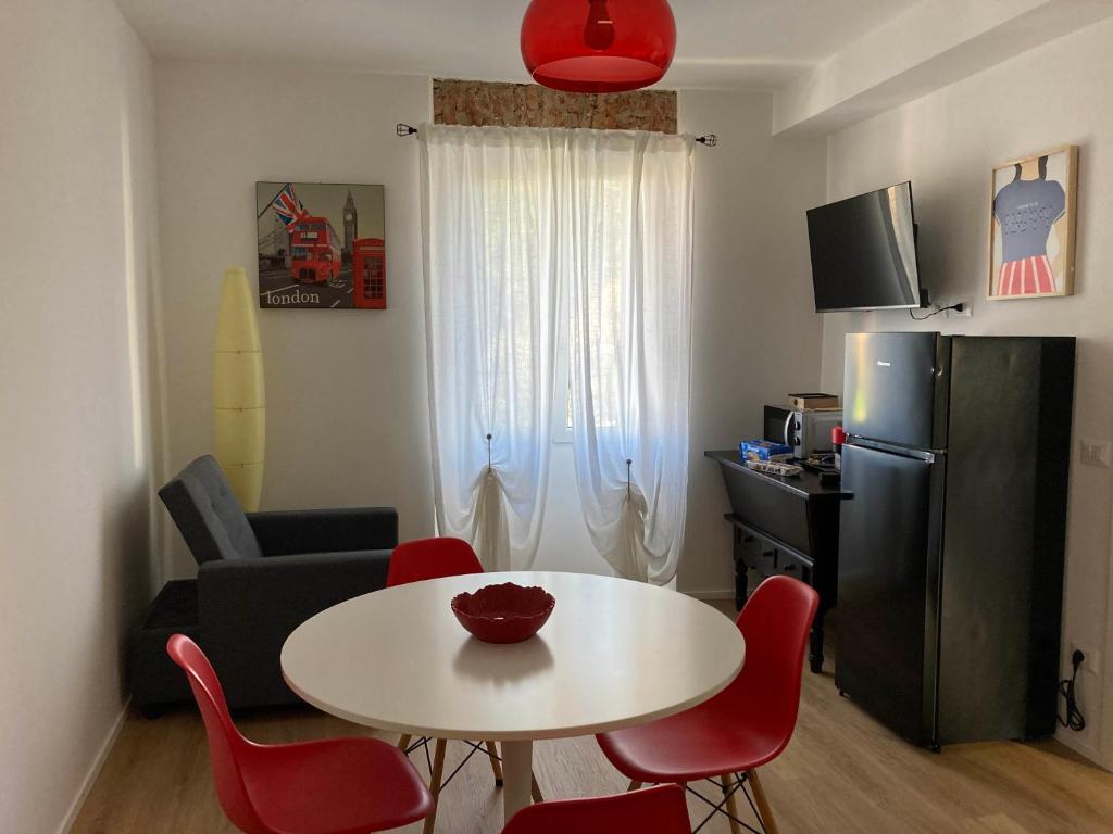 Nova MilaneseCasa Nova Luxury Apartment Suite Limoni的一间小客厅,配有白色的桌子和红色的椅子