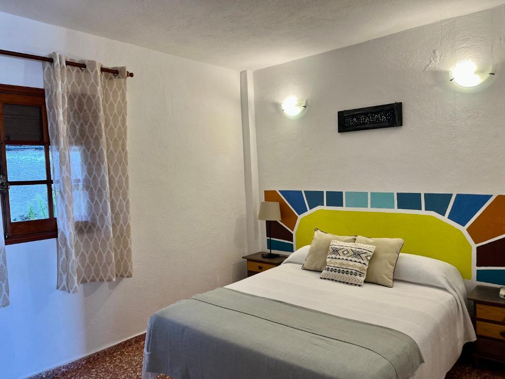 Monte de BreñaCasa Los Palitos的一间卧室配有一张带黄色床头板的床和窗户