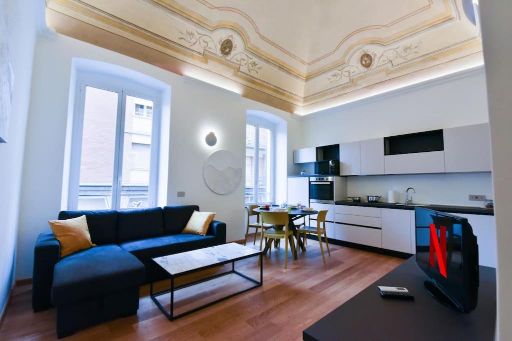 菲纳莱利古雷Loft 21 - Lussuoso ed Elegante a due passi dal Mare的一间带蓝色沙发的客厅和一间厨房