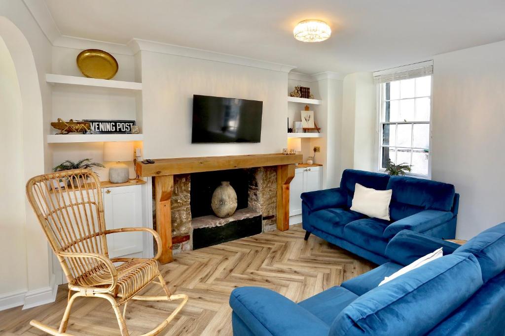 克里克豪厄尔Cwm Seren - Luxury Apartment的客厅设有蓝色的沙发和壁炉