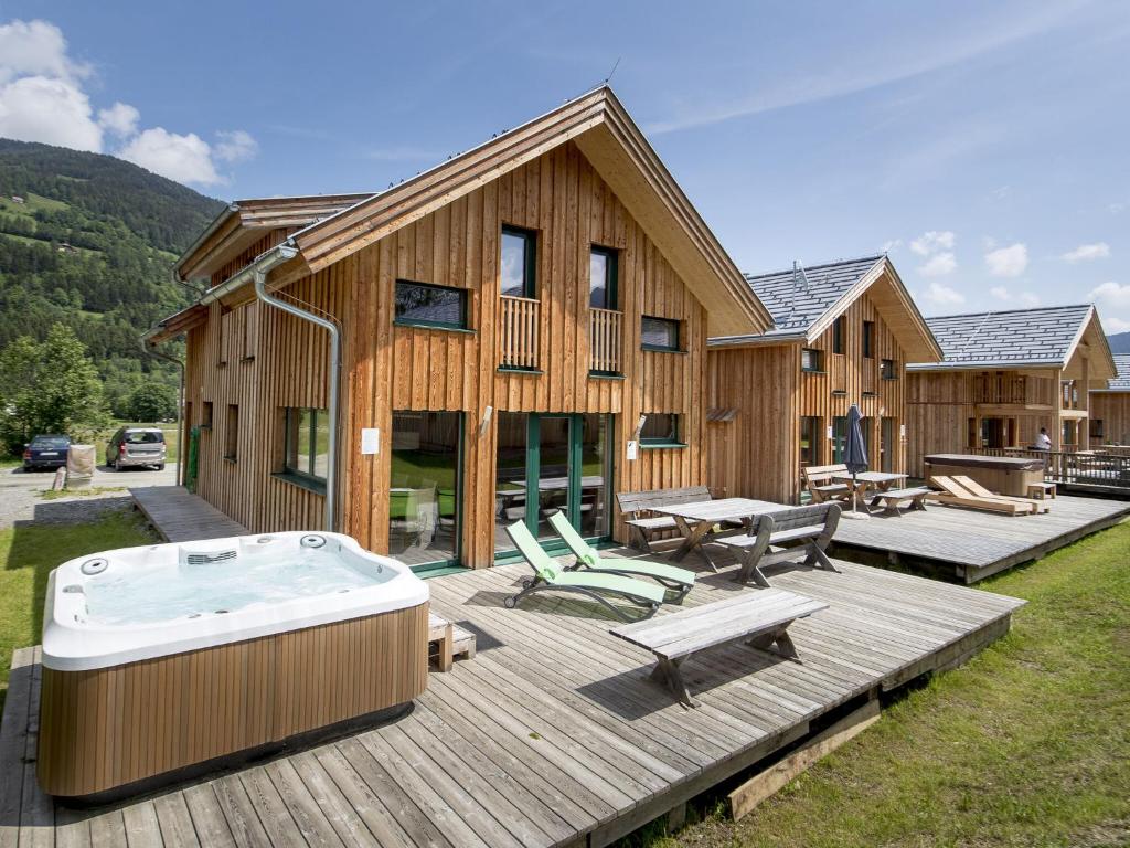 穆劳附近圣洛伦岑Wooden Chalet in Sankt Georgen ob Murau with Sauna的大型木屋,甲板上设有热水浴池