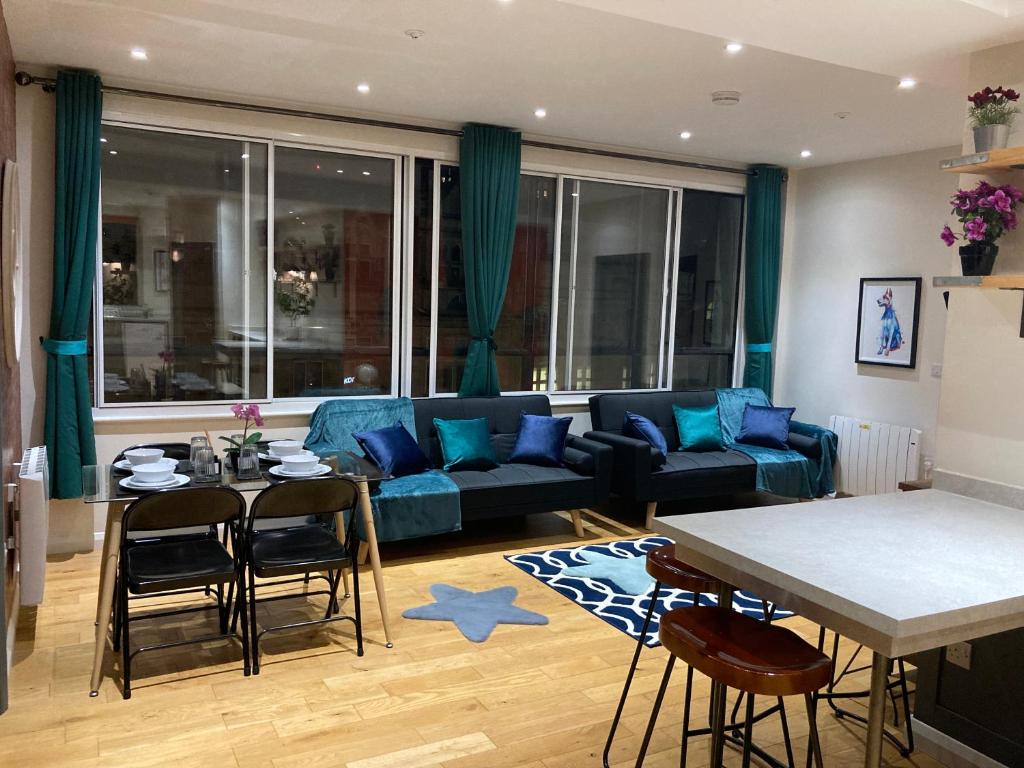 谢菲尔德Central Sheffield 3BED 3BATH IV Pent-Apartment的客厅配有蓝色的沙发和桌子