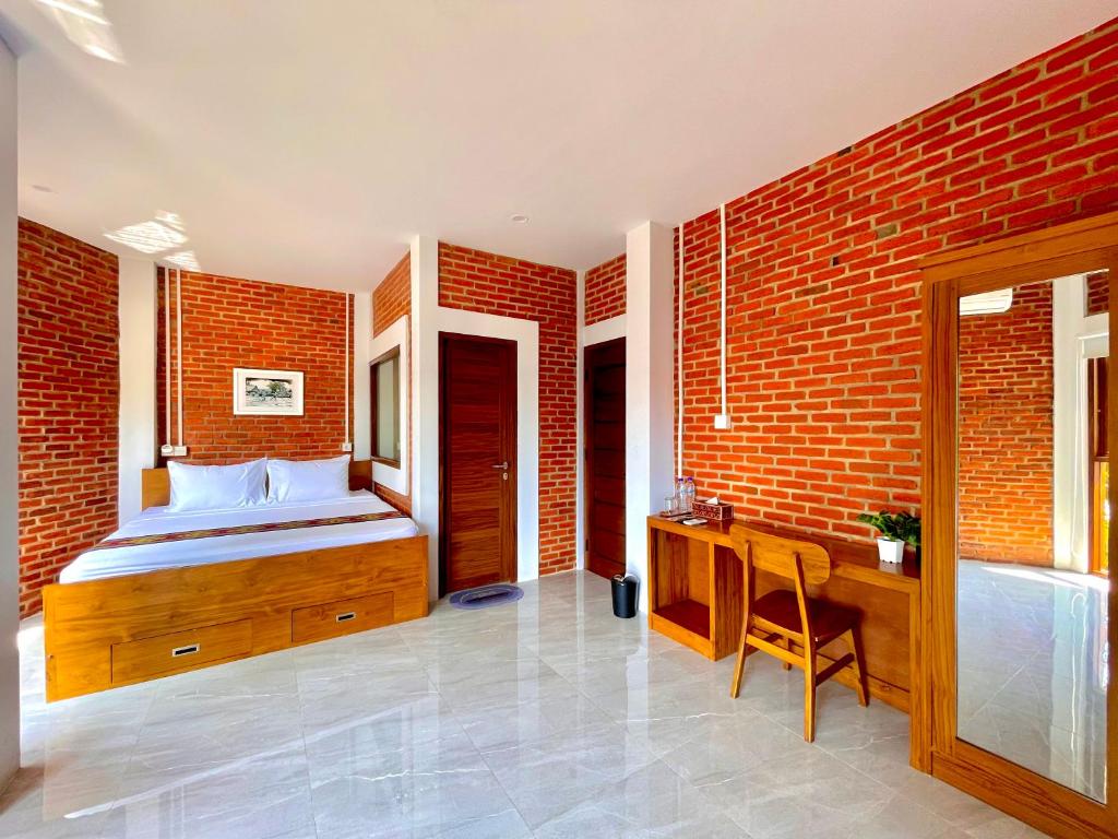 纳闽巴霍Puu Pau Hotel & Coffee Shop的一间卧室设有一张床和砖墙