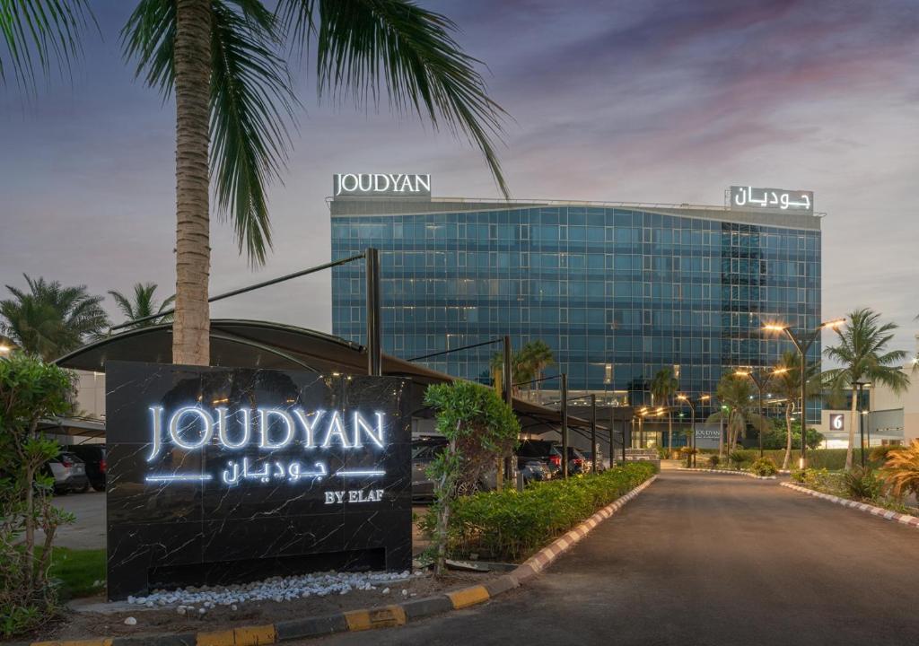 吉达JOUDYAN Red Sea Mall Jeddah By ELAF的街道前有棕榈树的建筑