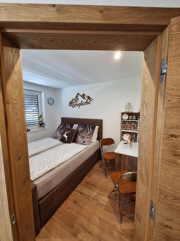 滕嫩山麓圣马丁Bergliebe的一间卧室配有一张大床和一张桌子