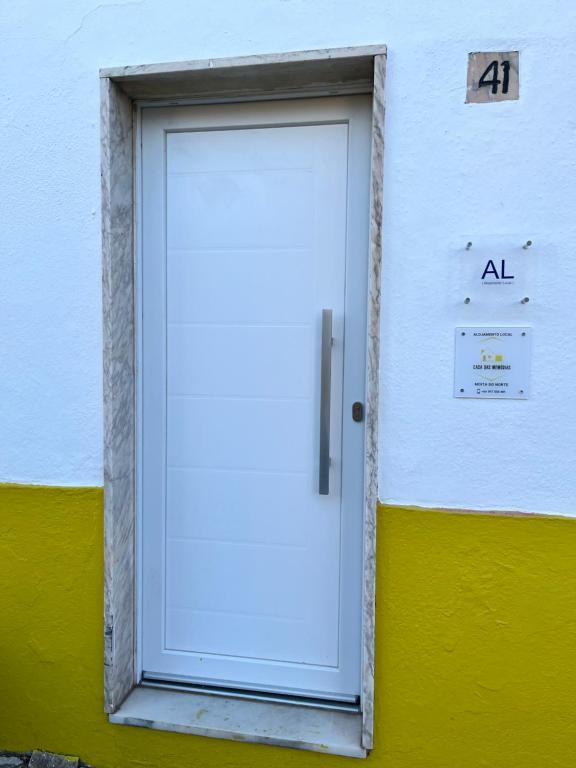 Casa das Memórias的黄色和白色建筑上的白色门