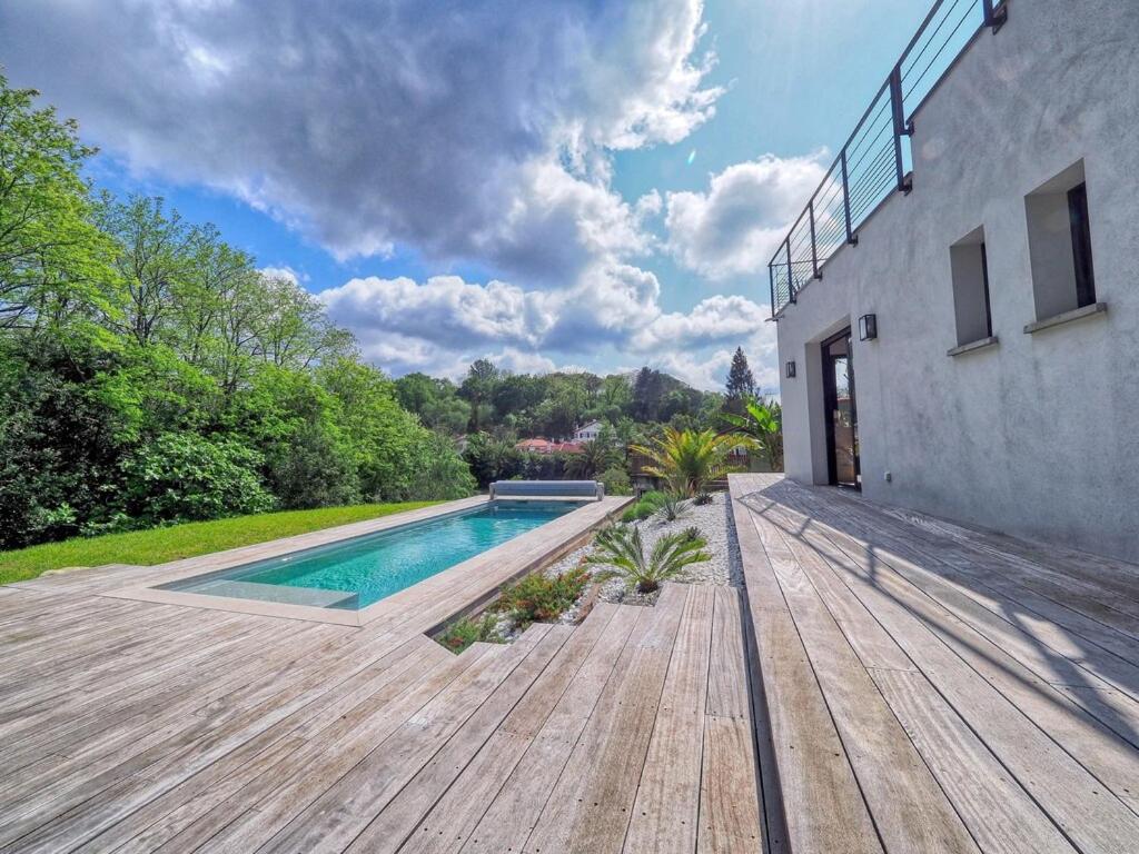 昂代VILLA MADHUKA - Chambres d'hôtes的后院设有游泳池和木甲板