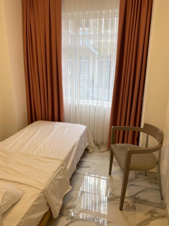 伊斯坦布尔yenikap hotel的卧室配有床、椅子和窗户。