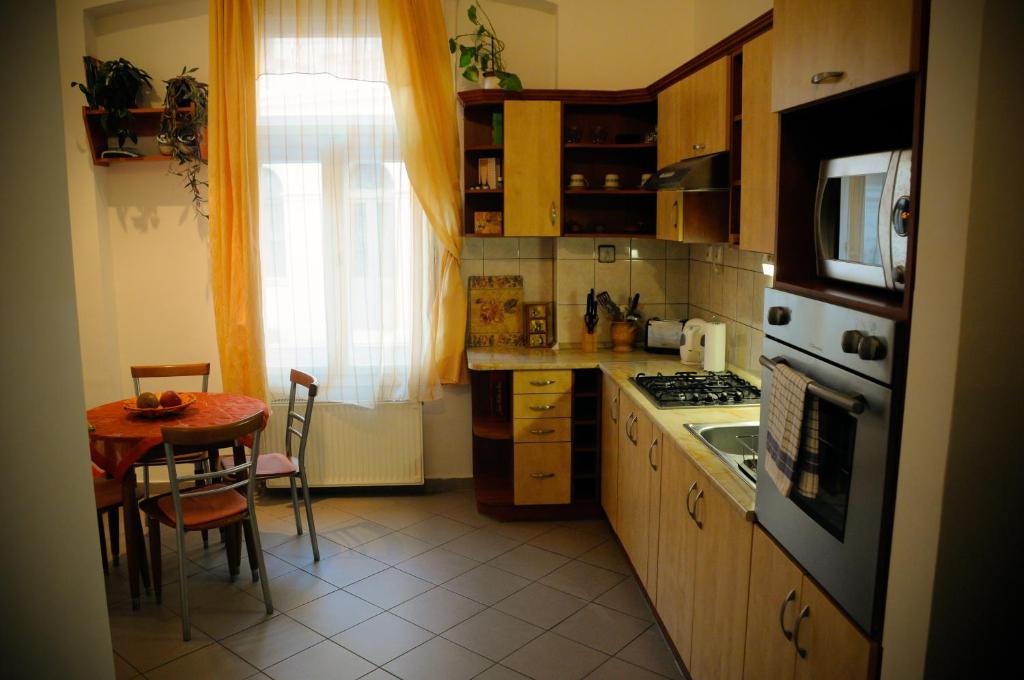 塞格德Sunny Apartman的厨房配有桌子和炉灶。 顶部烤箱