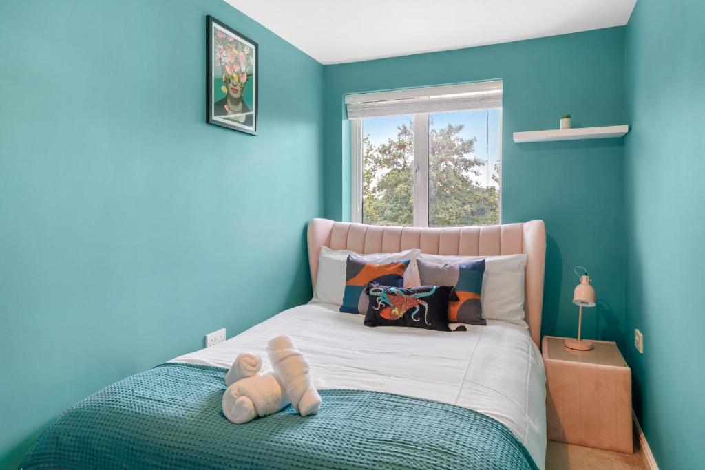 WoolstoneBeautiful 2 Bedroom Apartment MK Free Parking的蓝色卧室,配有一张带泰迪熊的床