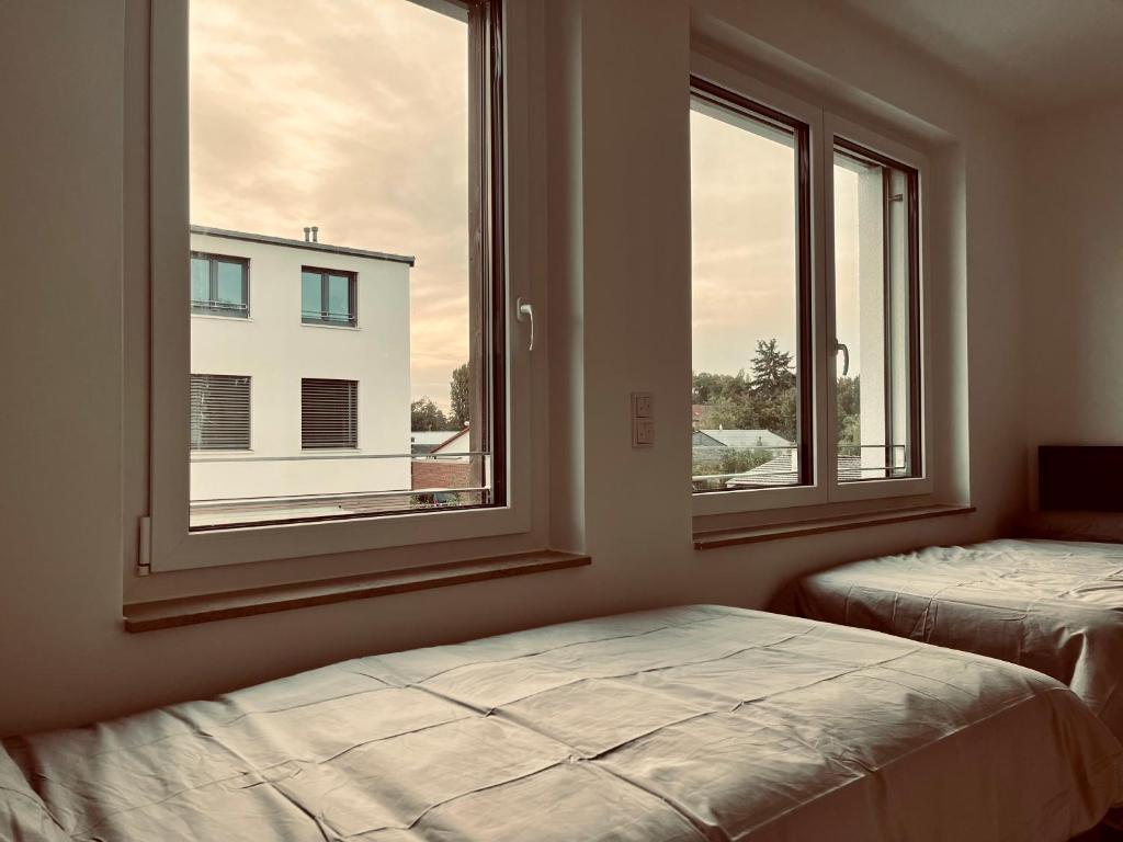 汉诺威Guestroom Hannover Messe的一间卧室设有两张床和两个窗户。