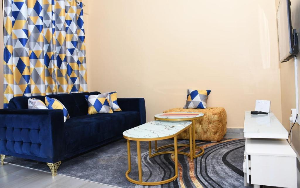 基苏木Intellicents Apartments的客厅配有蓝色的沙发和桌子