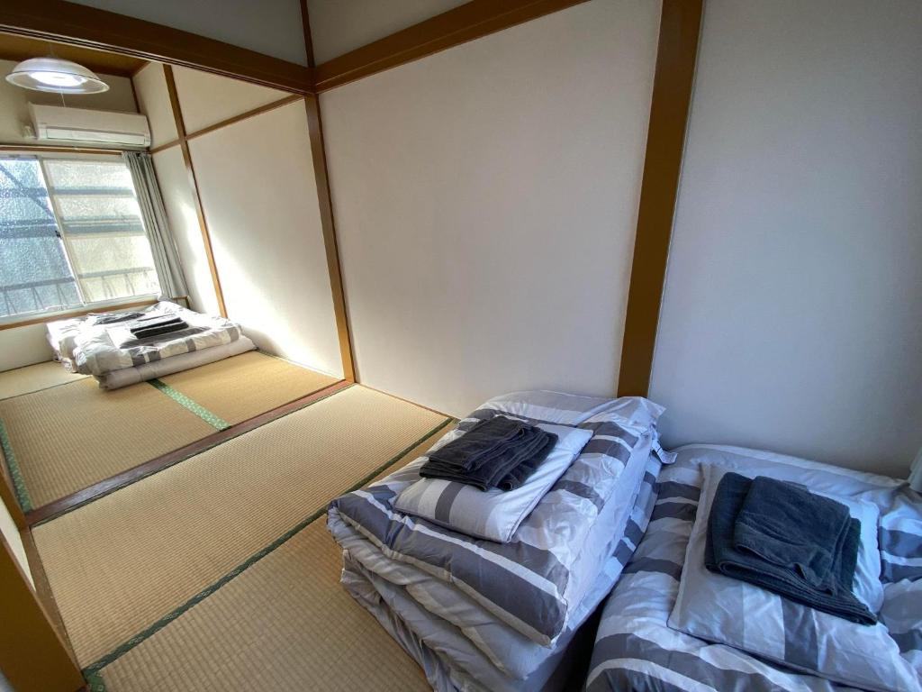 东京Little Bird Takinogawa #1的小房间设有两张床和窗户