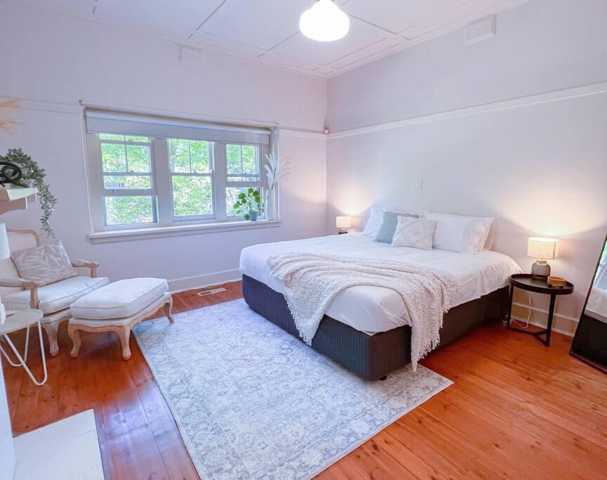 Alfredton• Parkside • Spacious central family retreat的白色卧室配有床和椅子