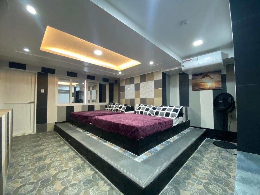 波尔多·格尼拉Anak Jay Ang的一间卧室,在房间内配有一张紫色的床