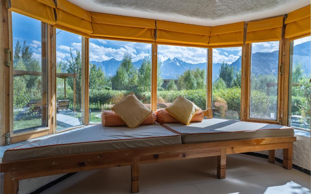 努布拉Lchang Nang Retreat-THE HOUSE OF TREES的一张位于带大窗户的房间内的床铺