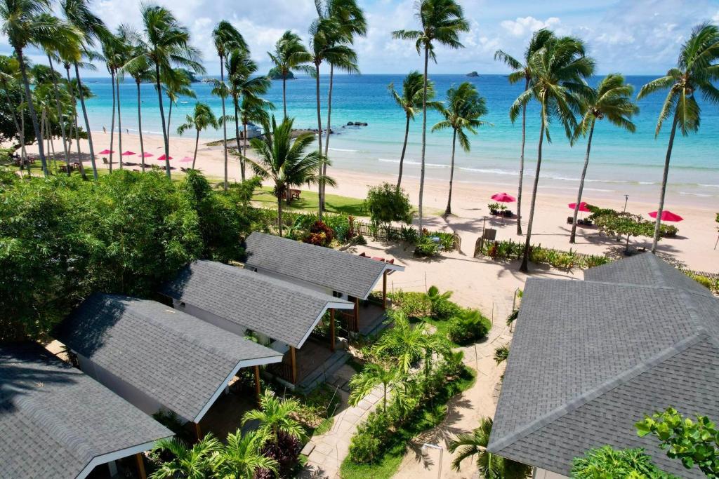 爱妮岛Nacpan Beach Villas的享有棕榈树和海滩度假村的空中景致