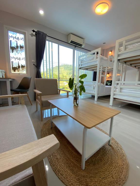 蔻立考拉克迈德居家旅舍的客厅配有桌子和一些双层床。