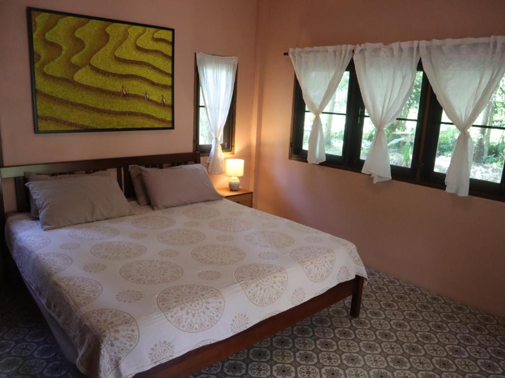 Cocohut Garden的一间卧室设有一张大床和两个窗户