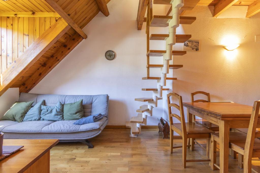 普拉德埃米塔La Cabanyeta de la Vall de Boí的客厅设有蓝色的沙发和螺旋楼梯。