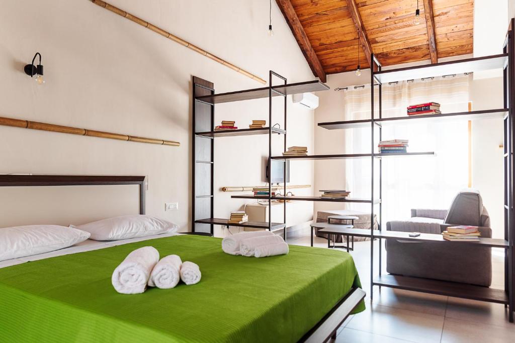 PeritoBorgo del Bambù的一间卧室配有一张绿色的床、椅子和一张书桌