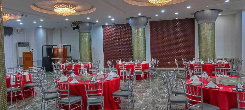 桑托斯将军城PHELA GRANDE HOTEL的宴会厅,室内配有红色的桌椅