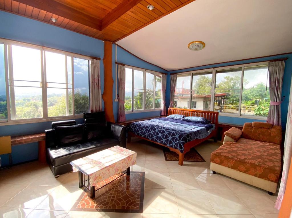 Ban Khao Ya Nua查克民宿的一间卧室配有一张床、一张沙发和窗户。