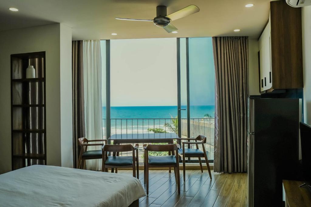 岘港Anstay Beach Da Nang的一间带桌椅的卧室和一个阳台