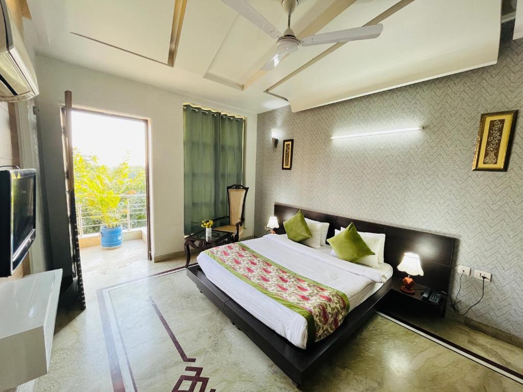 古尔冈Hotel Dayal Regency near IMT Chowk Manesar, Manesar的一间卧室设有一张大床和一个大窗户