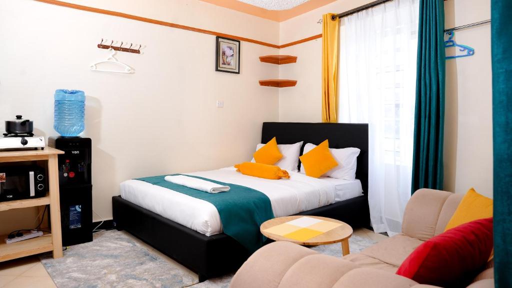 奈瓦沙Shalom Apartments的一间卧室配有一张床,客厅配有沙发