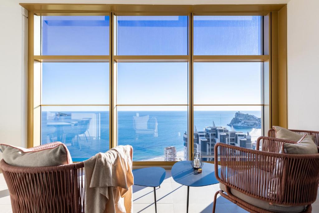 贝尼多姆Intempo planta 22 ! vistas impresionantes !的客房设有桌椅和大窗户。