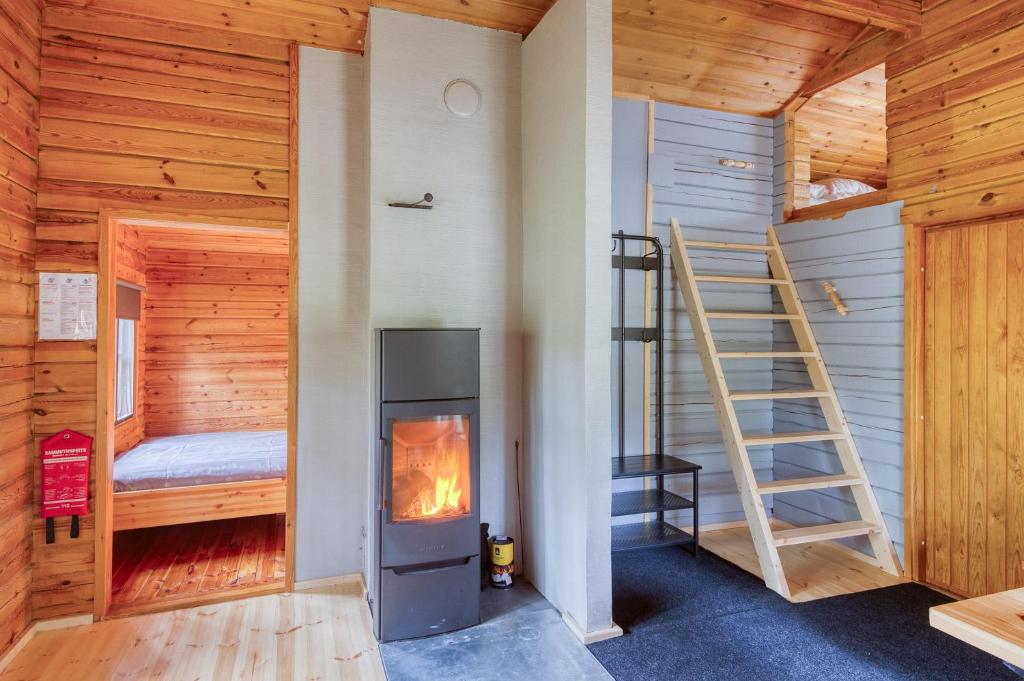 KalantiPinetree Cottages Cozy log cabin的小木屋设有壁炉和梯子