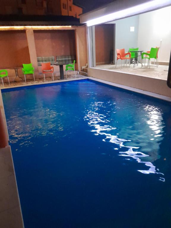 莫斯塔尔Apple Line Appartments的游泳池,带椅子和蓝色的水