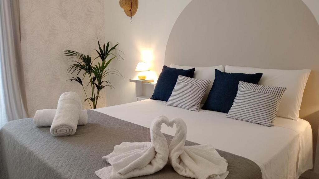 马蒂纳塔Meridiana case al mare centro的卧室的床上有两条天鹅绒毛巾