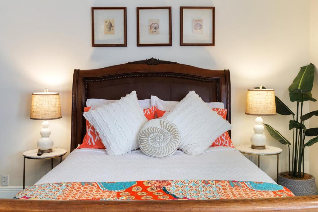 基韦斯特Studio Blue的一张带橙色和白色枕头的床以及两盏灯