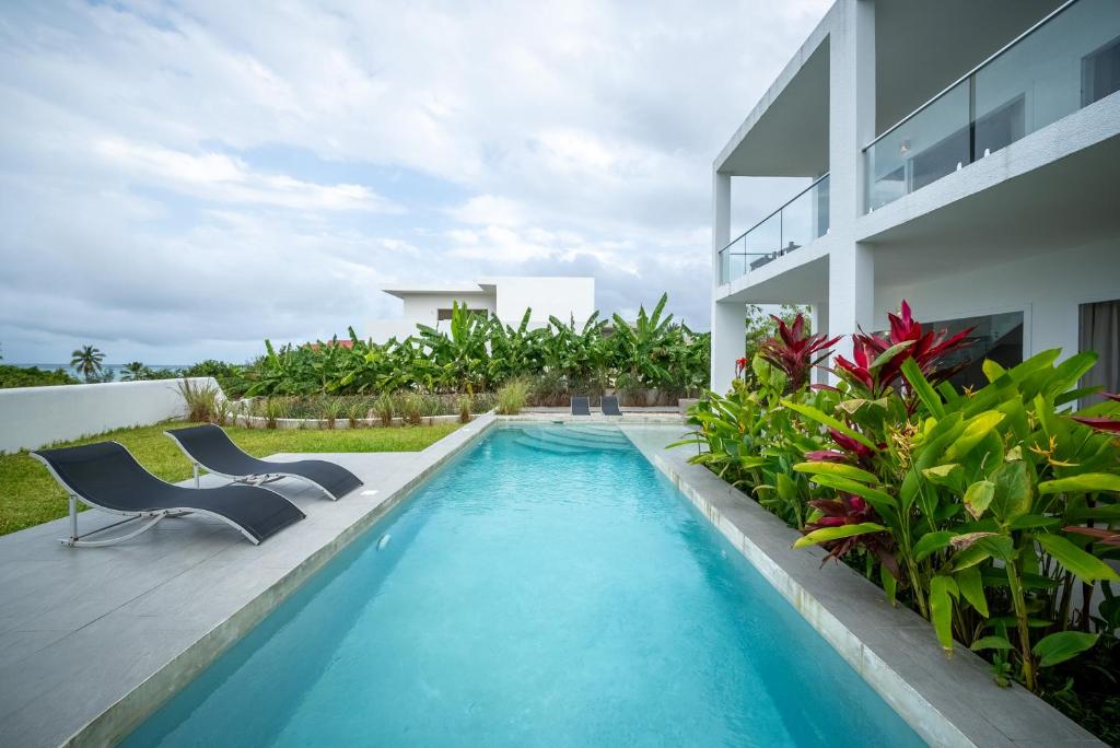 吉汶瓦OceanView Villa Manzini with Private Pool ZanzibarHouses的一个带两把椅子的游泳池以及一座房子