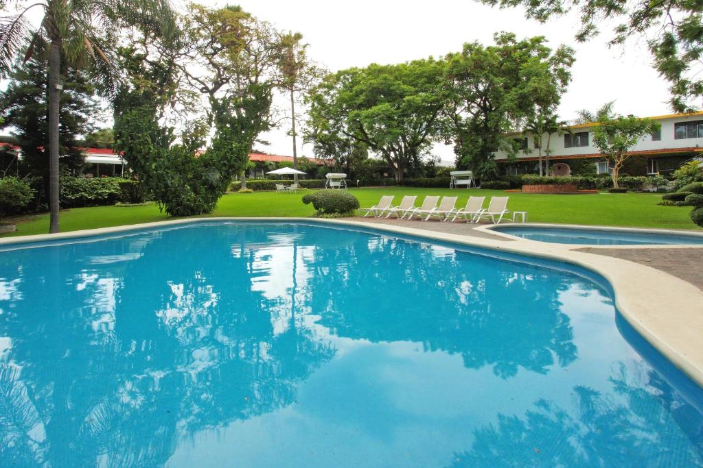 库埃纳瓦卡弗洛蕾丝花园酒店的庭院里的一个蓝色海水大型游泳池