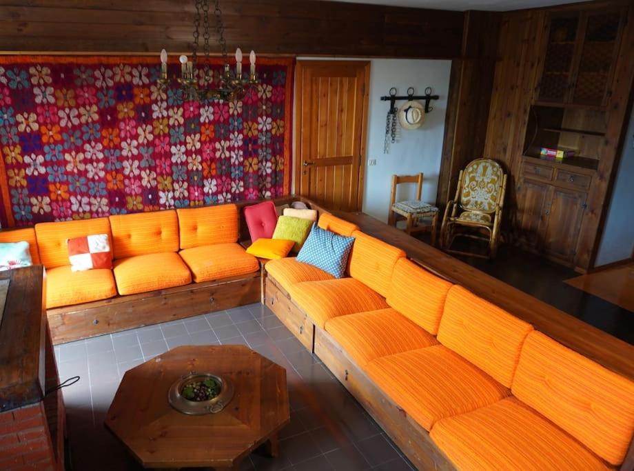 利维松多里Il Rifugio da Aldo - Rivisondoli的客厅配有橙色沙发和桌子