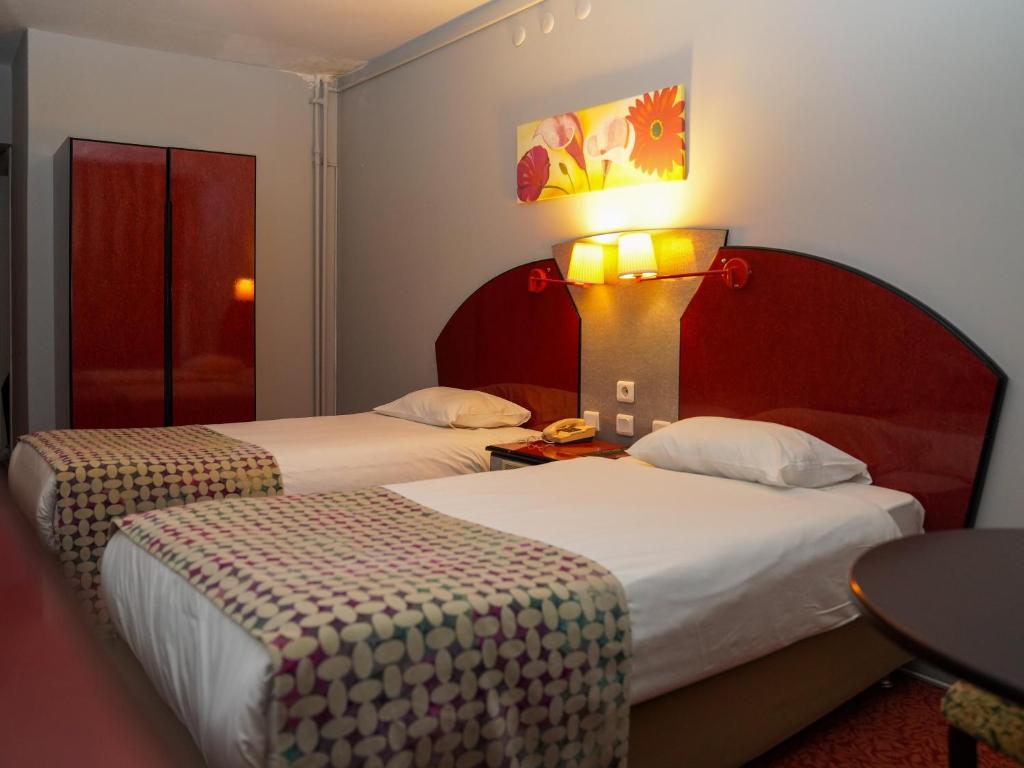 班德尔马HOTEL EKEN的酒店客房设有两张床和一张带台灯的桌子。