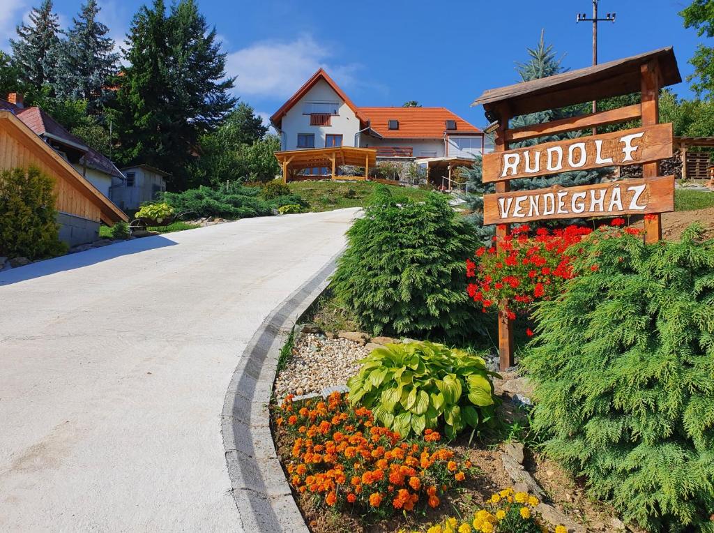 韦莱姆Rudolf Vendégház的院子中带有标志和花的车道