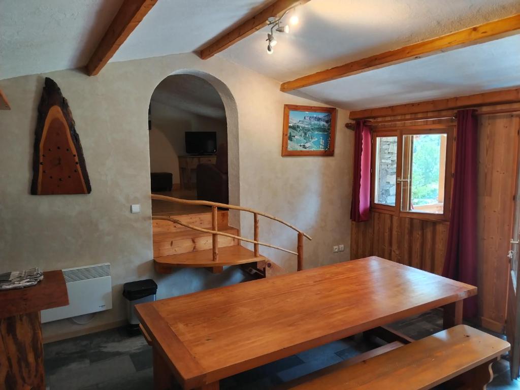 阿尔克河畔博讷瓦勒Chalet Le Grand Méan的一间带木桌和楼梯的用餐室