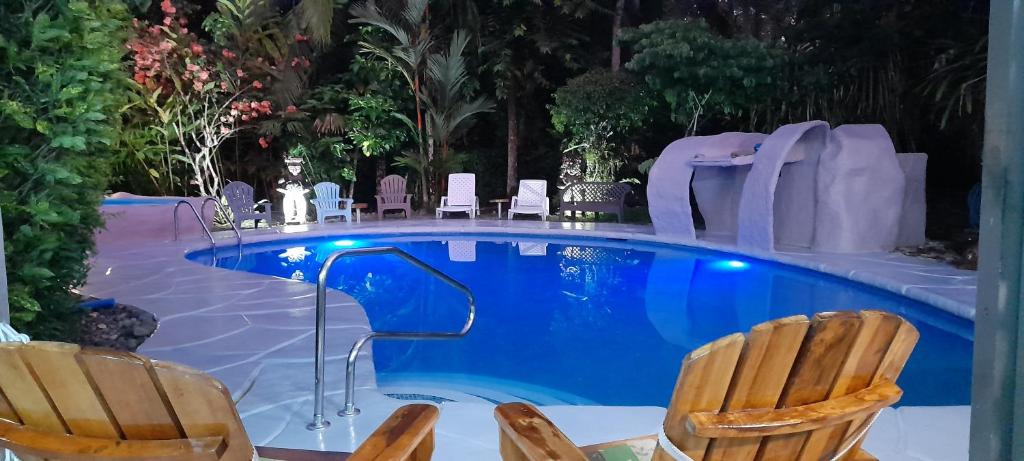 卡维塔Hotel El Colibri Rojo - Cabinas - Le Colibri Rouge的一个带两把椅子的游泳池和一个游泳池滑梯