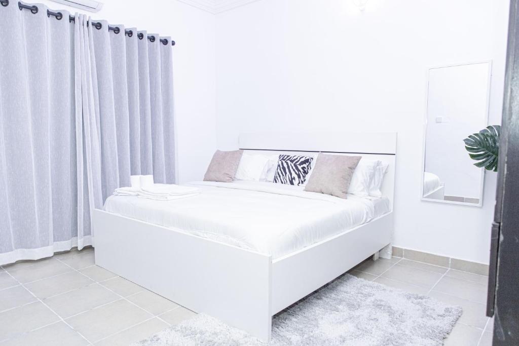 莱基Novara Apartments的白色的床上,带窗帘
