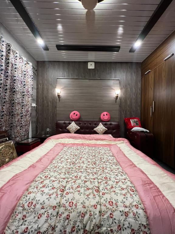 古尔马尔格Everest Guest House的卧室配有一张带粉红色枕头的大床
