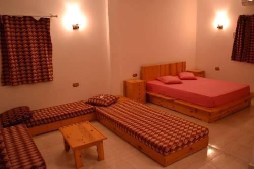 努韦巴Big Dune camp的一间卧室配有两张床、一张长凳和一张桌子