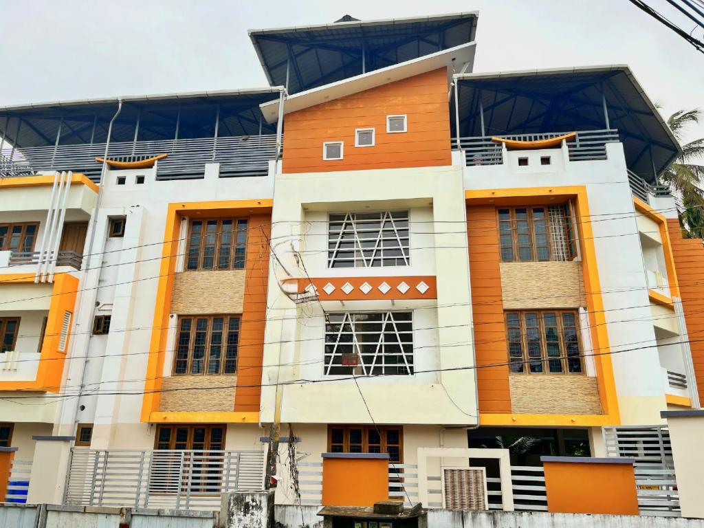德里久尔Thrissur Villas Home Stay的一座橙色和白色的建筑